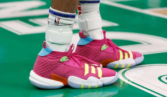 View of Trae Young's pink and yellow adidas shoes.